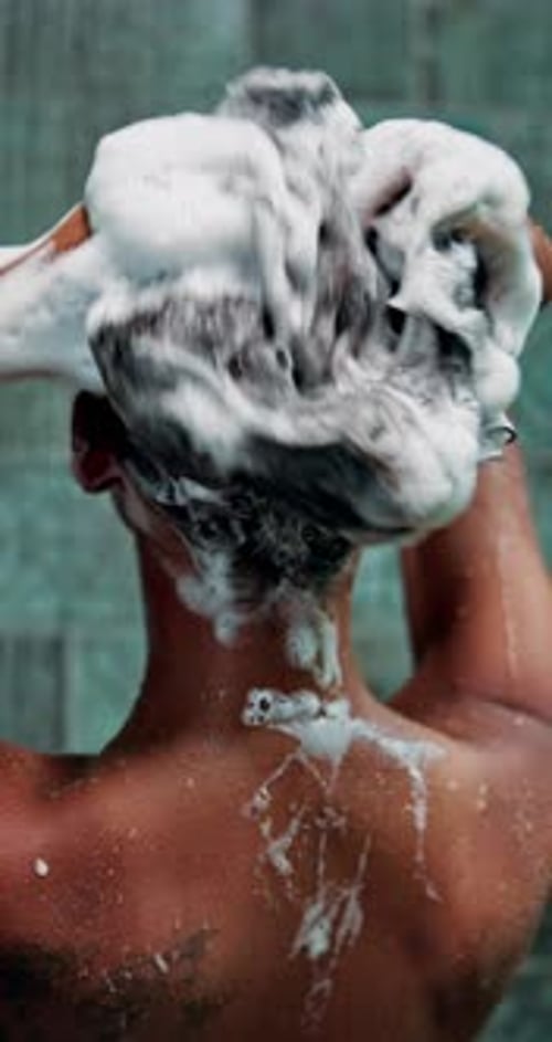 Person Washing Hair with Shampoo in Shower