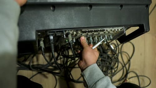 Close-up of a man tuning the acoustics from the audio mixer in the studio
