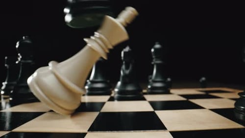 Closeup Hand Moving Black Chess Queen Figure and Checkmate Opponent During Chessboard Competition