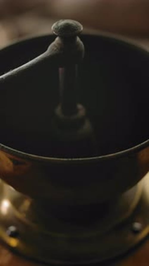 Coffee Beans Dropped into Old Fashioned Grinder