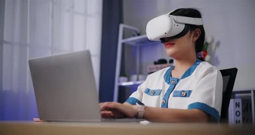 Woman Uses VR Headset While Working on Laptop