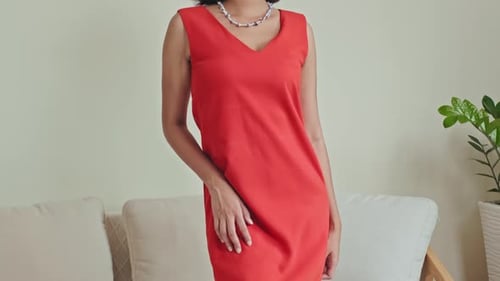 Woman Models Sleeveless Red Dress with Necklace Indoors