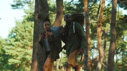 Young Couple Hiking in a Lush Green Forest
