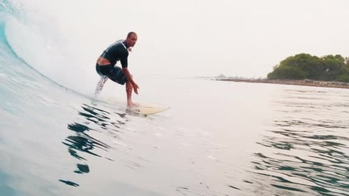 Surfing in Maldives. Man surfs the ocean wave in tropics
