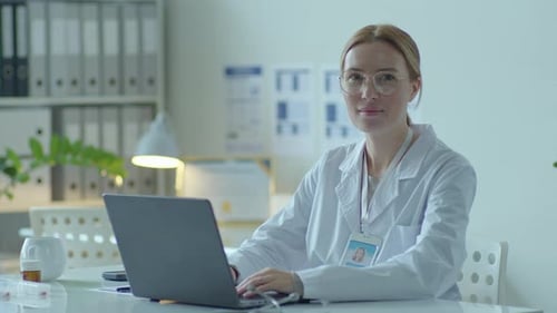 Professional Female Doctor Posing at Camera in Medical Office