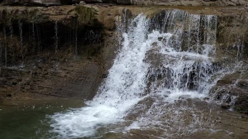 A Beautiful Waterfall in the Mountains in the Forest