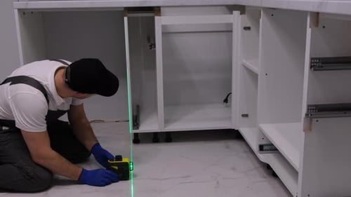A Professional Craftsman Will Install Furniture in the Kitchen Using a Highprecision Construction