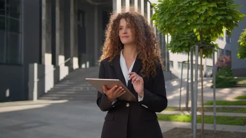 Woman Uses Tablet in Front of Building