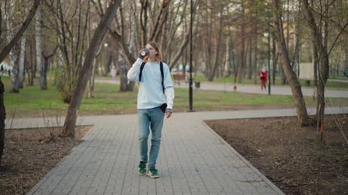 Young Individual Takes Walk Young Male is Leisurely Wandering Through City Streets an Energetic