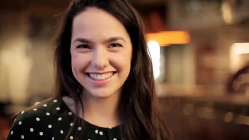 Attractive Young Woman Smiles and Laughs at Camera