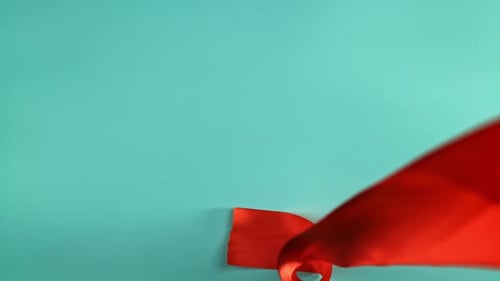 A Red Ribbon Falls on the Table Filmed on a Highspeed Camera at 1000 Fps