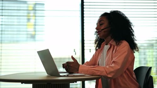 Professional Woman Engages in Online Video Call From Modern Office Workspace