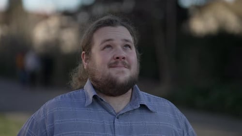 Un jeune homme plein d'espoir en surpoids qui regarde le ciel avec FOI et GRATITUDE.