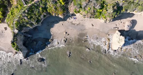 Aerial top view of ocean blue waves break on a beach.
