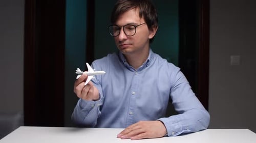 Man Holds Toy Airplane and Moves it in Hand