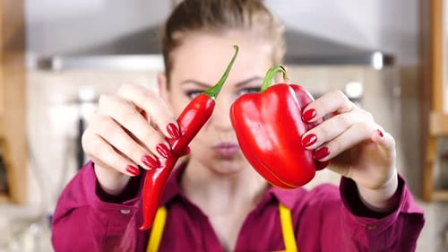 Woman Holding Red Peppers in Kitchen