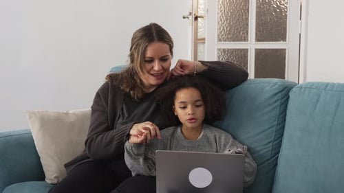 Woman and child use a laptop together indoors