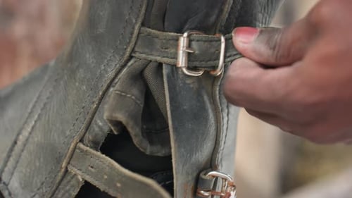 Boucle de guêtre en cuir à fermeture par aiguilles noires sur botte d'équitation, sangle de fixation stable et résistante à la neige