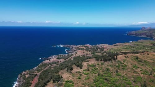 O drone de alta altitude gira em torno da formação rochosa do penhasco que se estende até o oceano
