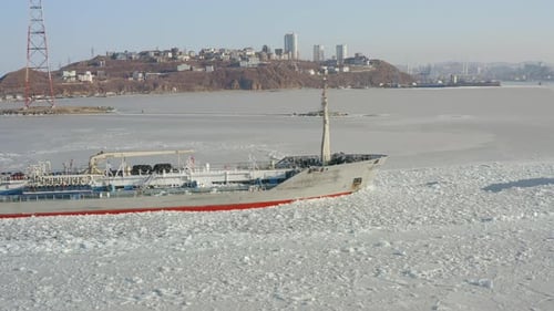 Oil Tanker Among the Ice Passes the Frozen Strait in Winter