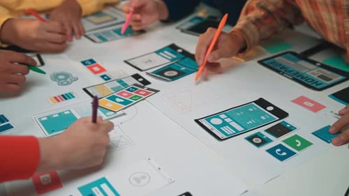Session de conception collaborative avec diverses mains créant des wireframes et des prototypes