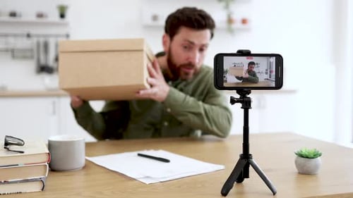 Man Recording Video About Opening a Box At Home