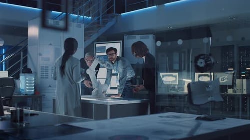 Team of Scientists Discussing Robotic Arm in Laboratory