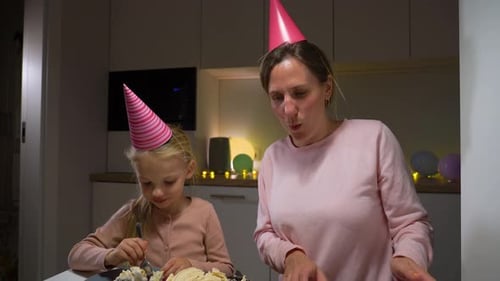 Mother and Daughter Enjoying Cake at Home Birthday
