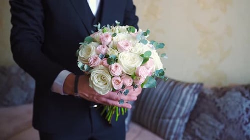 Man Holds Wedding Bouquet of Roses in Hands