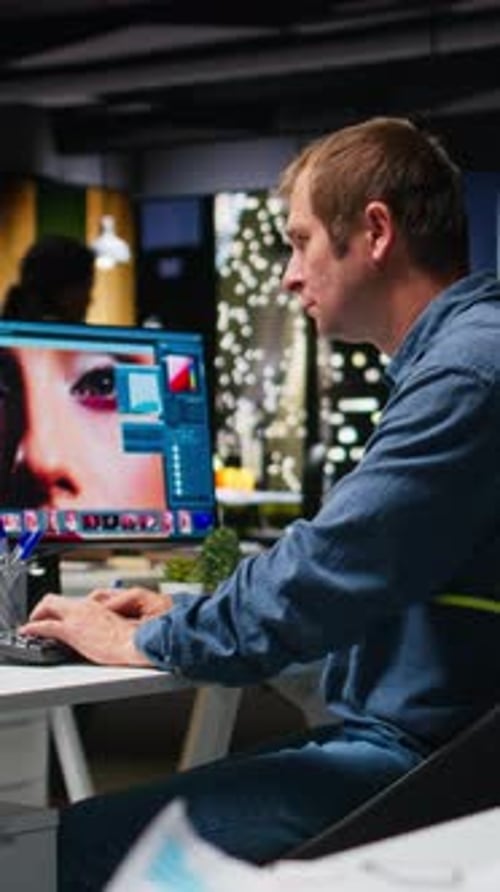 Man Editing Photos on Computer in Modern Office