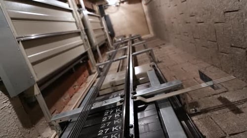 Elevator lift cabin moves up inside illuminated elevator shaft with hydraulics with many floors slow