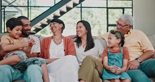 Happy Family Laughing Together on Couch at Home