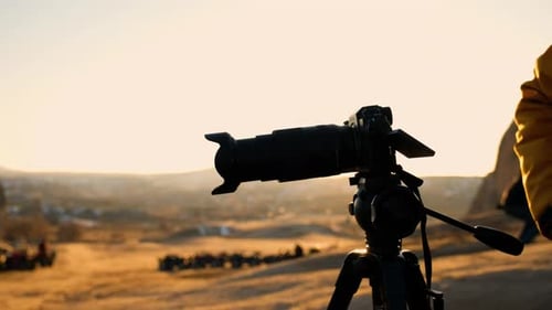 Camera Captures Desert Landscape with Vehicles at Sunrise