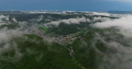 Drohnenflug über Wolken und grünen frischen Wald im hügeligen Europa Deutschland Luftaufnahme rund um den Nebel
