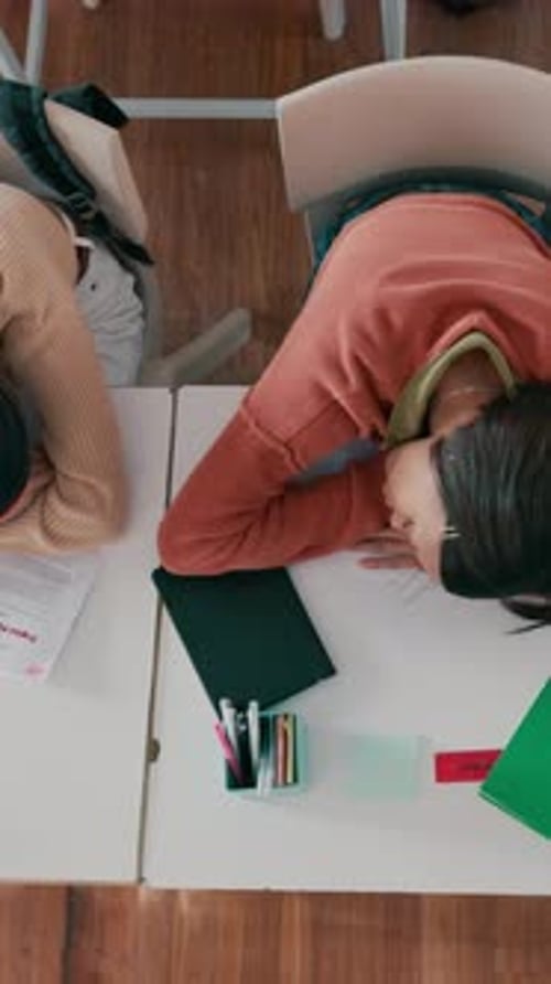 Above, students and sleeping in classroom with fatigue, difficult assessment and education burnout