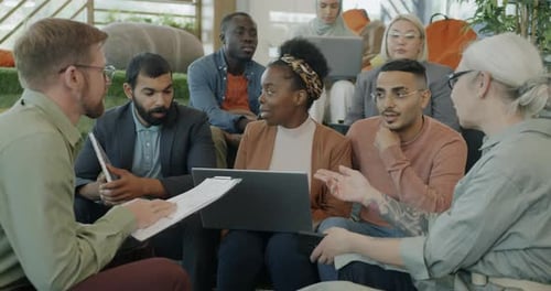 Multicultural Group of Colleagues Discussing Business Ideas Talking in Coworking Center