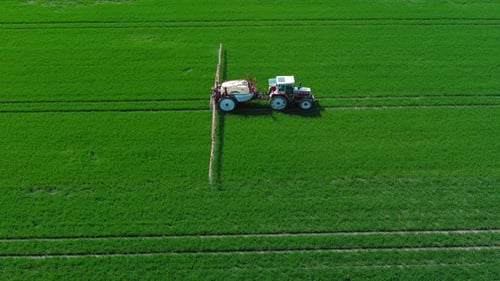 Farming Tractor Crop Sprayer on Green Field