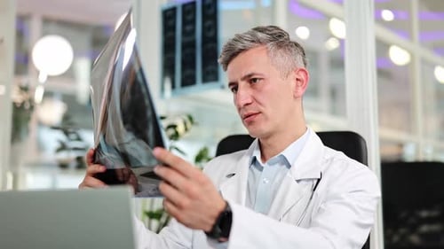 Professional Physician Examines Patient Xray in Modern Clinic for Medical Diagnosis