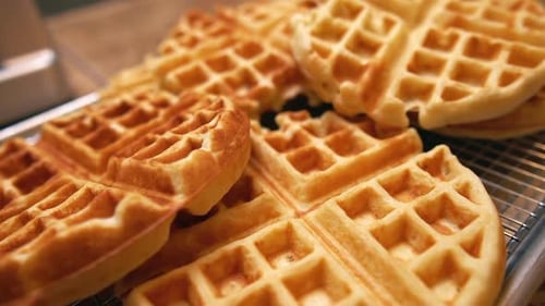 Freshly made waffles cooling and ready for a big family breakfast feast - push forward close up