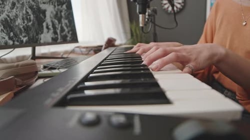 Person Playing Electronic Keyboard in Home Studio