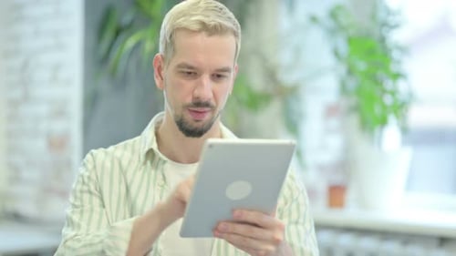 Young Man Using Tablet at Home