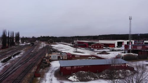 Drohne steigt über dem Bahnhofsgelände in Vansbro, Schweden. Es ist ein ruhiger Wintertag.
