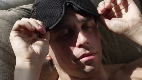 A Man Puts on a Sleep Mask