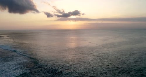 Aerial Shot Fly Over Blue Ocean And Tropical Beach Cloudy Sunset Dawn at Bali Indonesia Southeast As