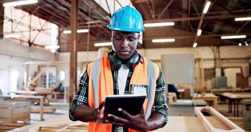 Man, carpenter and tablet at factory, typing or check notification for furniture manufacturing