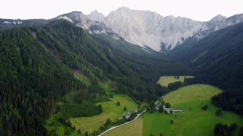 A farmhouse in a valley in the high Austrian mountains. Aerial view.