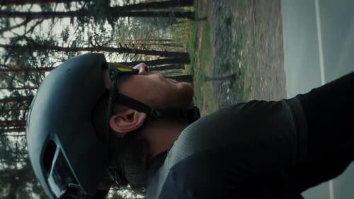 Retrato de ciclista masculino andando de bicicleta de estrada no parque da cidade. Vídeo vertical