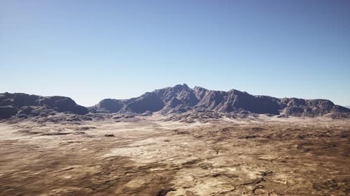 Vast Dry Terrain Featuring Mountains and Sparse Vegetation Under Bright Sunlight