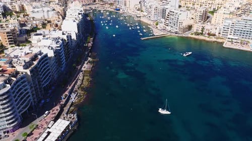 Aerial Sweep Over Sliema Bay Boats and Tower Road Promenade
