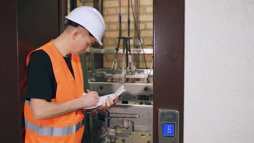 Engineer Inspects Quality of Elevator Parts Complex Modern Elevator Equipment Male Utility Worker